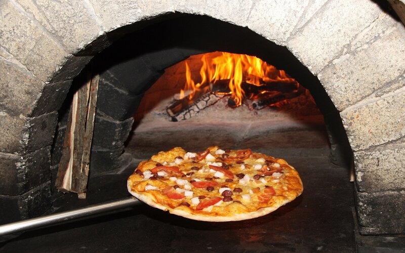 Pizza baking in a wood-fired oven