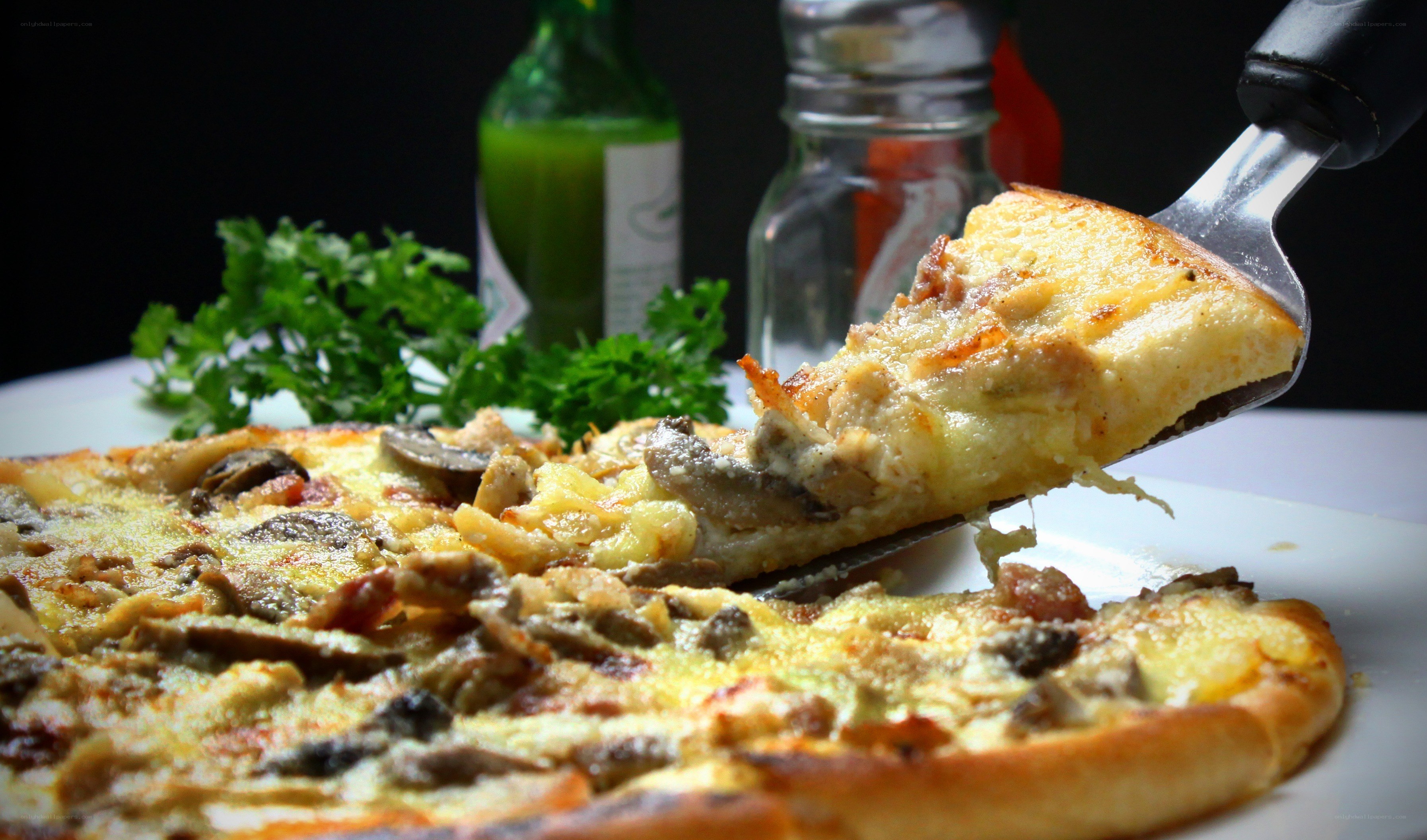 Pizza slice being lifted from a whole pizza