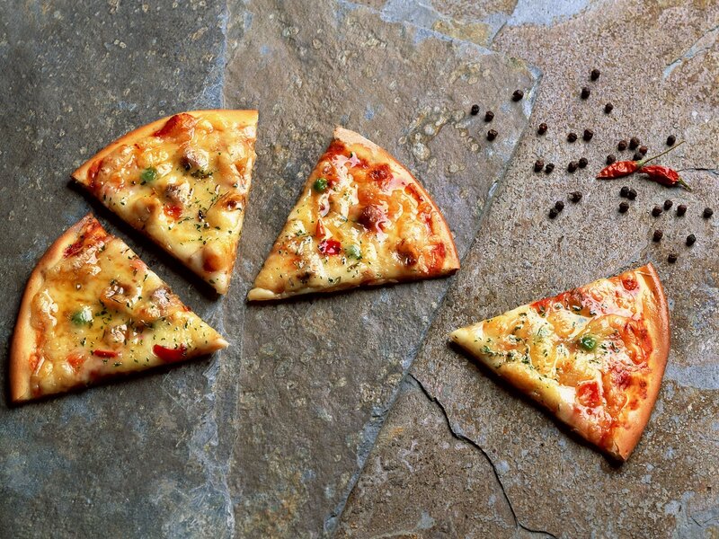 pizza slices on stone surface