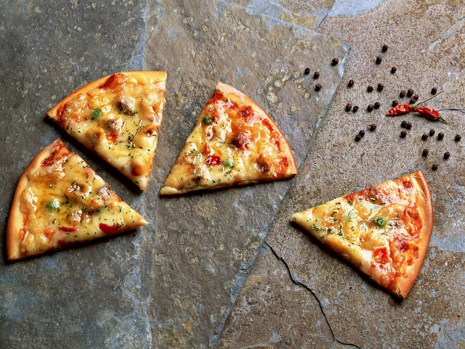 pizza slices on stone surface