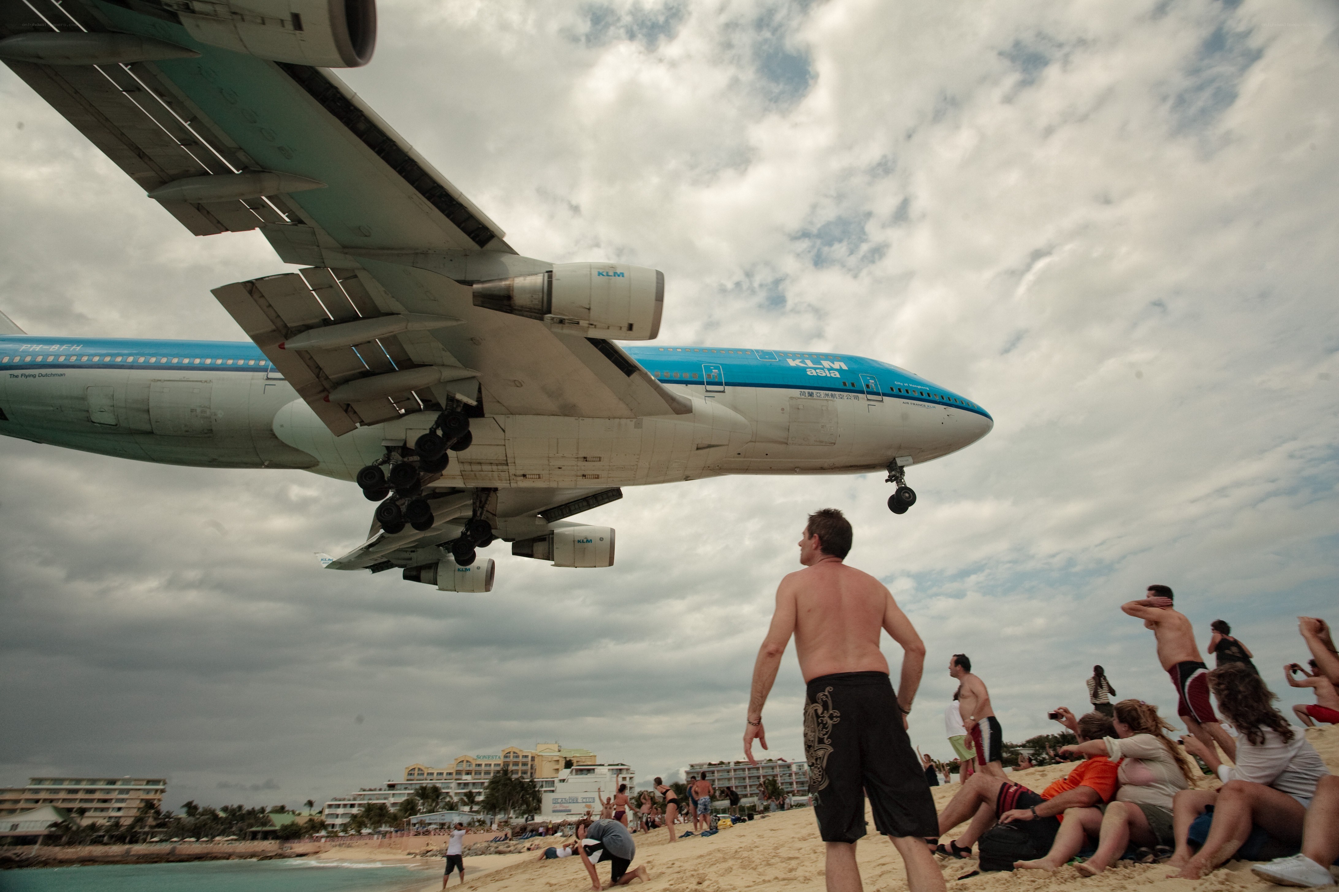 Plane flying over beach crowd