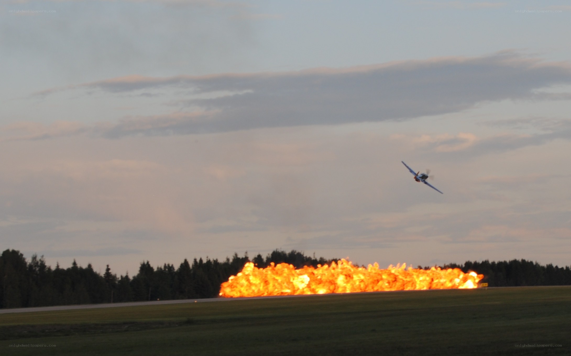 Plane flying over fire on runway