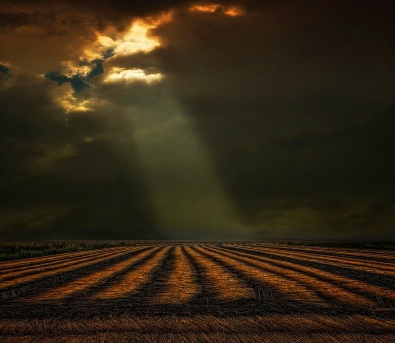 Plowed Field under Stormy Sky