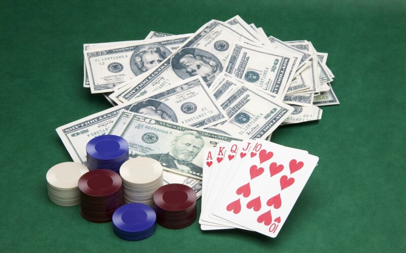 Poker cards and cash on green table