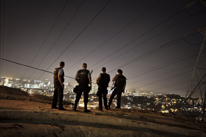 Police officers overlooking a city at night