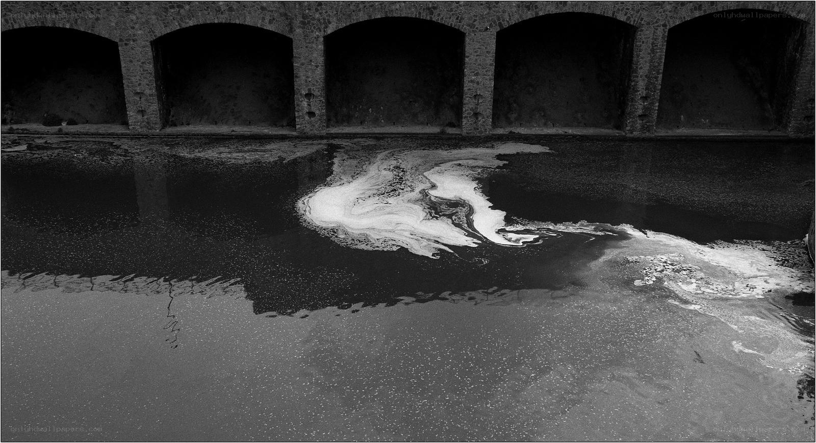 Polluted water under stone arches