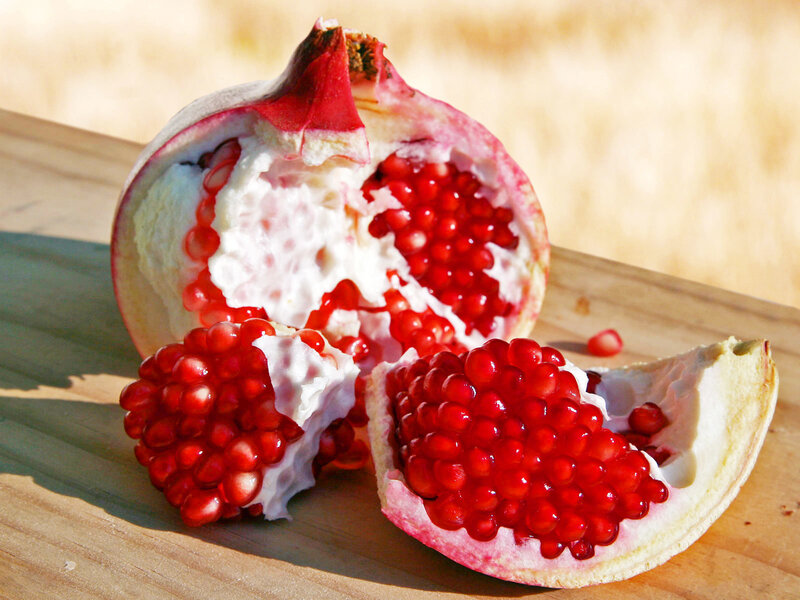 Pomegranate cut open on wood