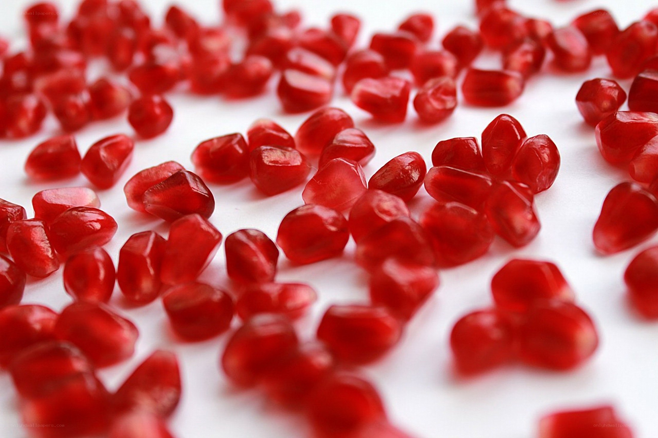 Pomegranate seeds on white
