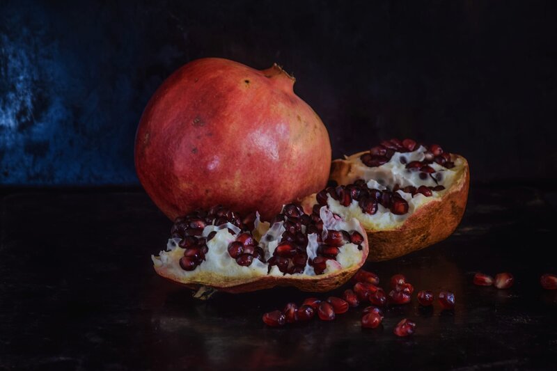 Pomegranates on Dark Surface — Red