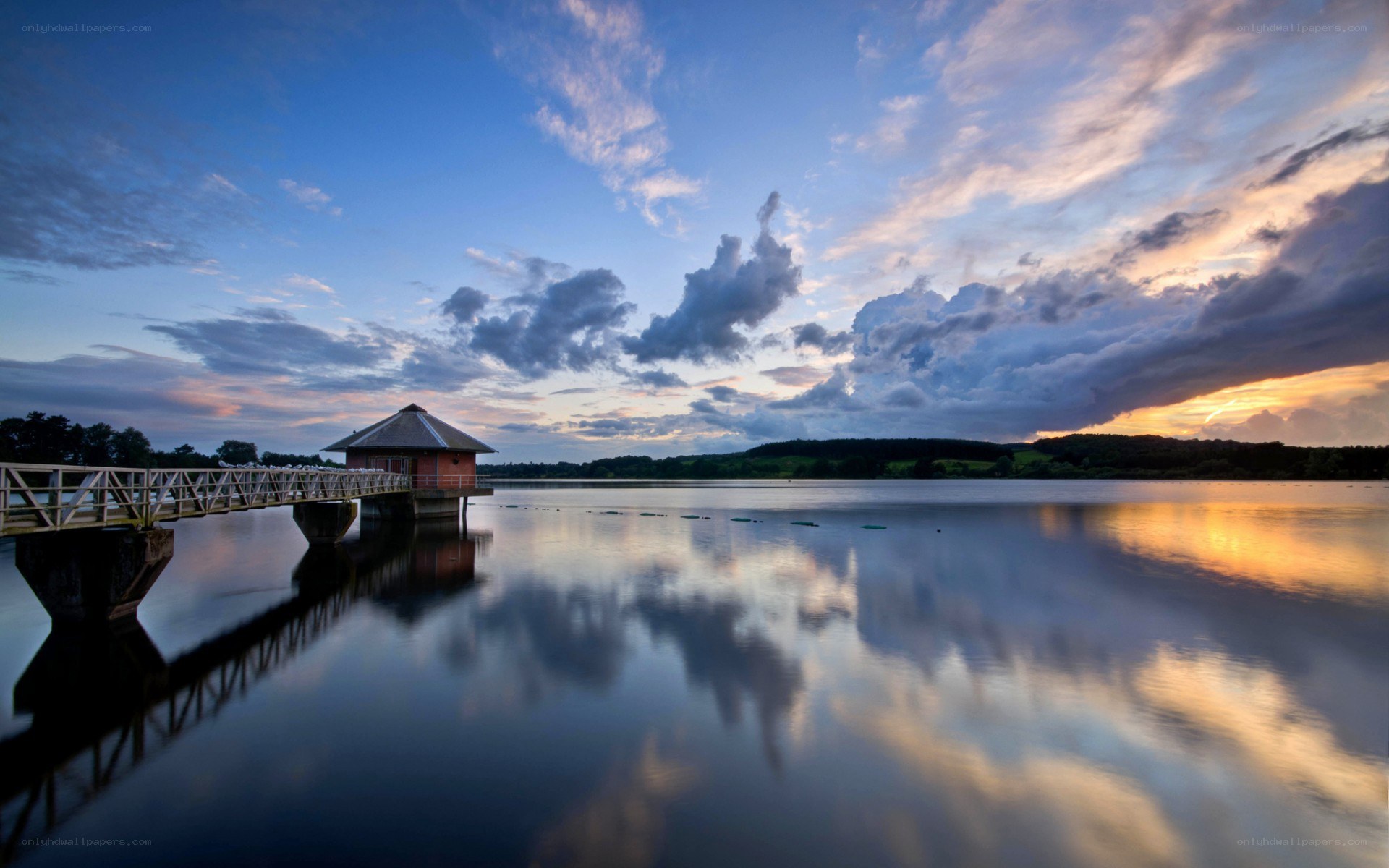 Pond with a boathouse at sunset