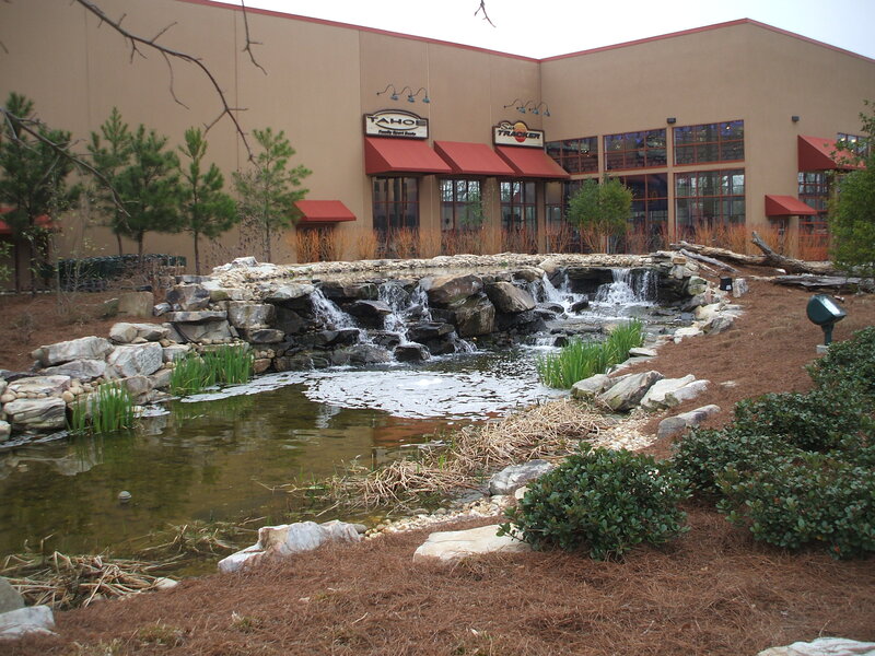 Pond with waterfall in front of building