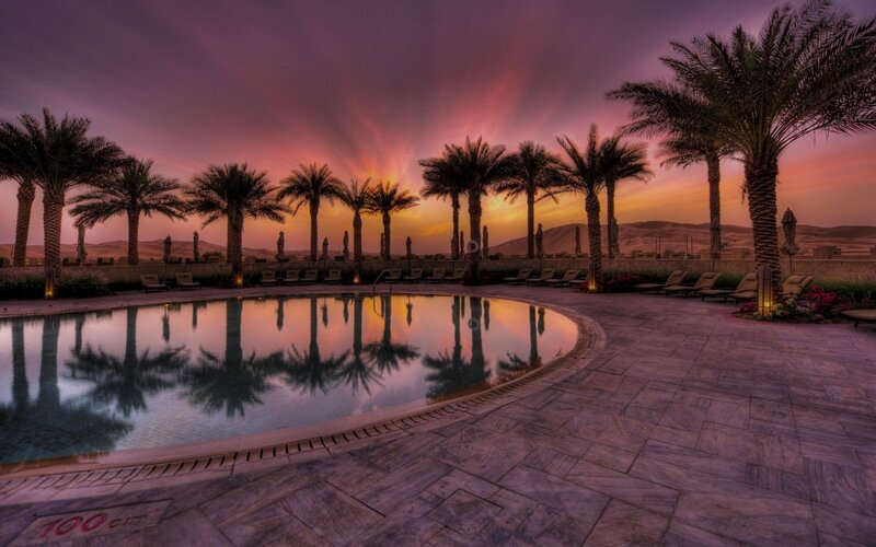 Pool at sunset with palm trees