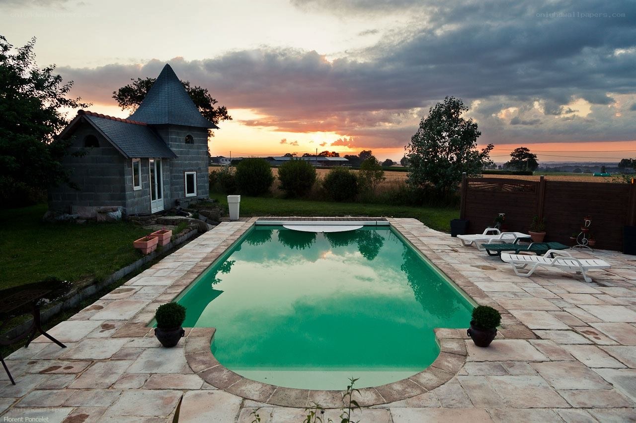 Pool at sunset with stone house