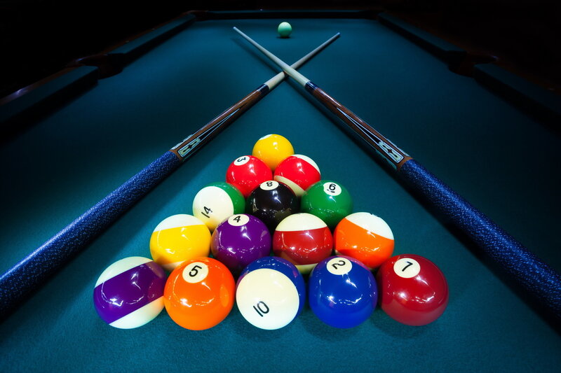 Pool balls and cues on green table