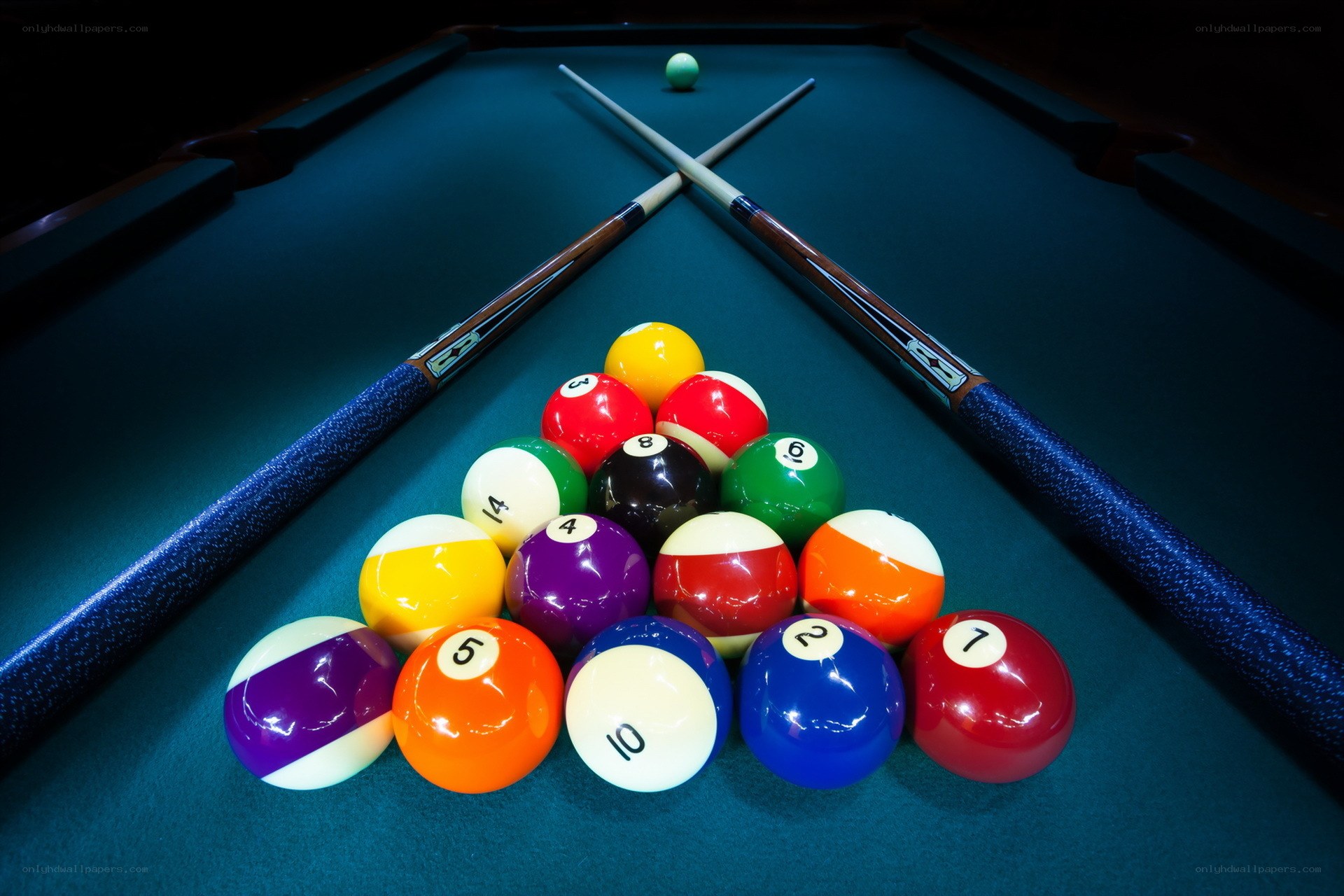 Pool balls and cues on green table