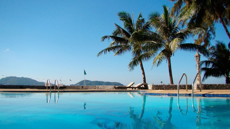 pool with palm trees and ocean view
