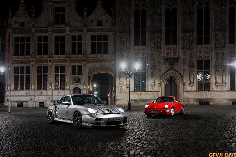 Porsche cars at night in a square