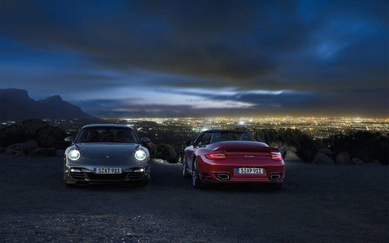 Porsche cars at night with city view