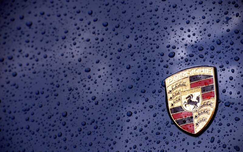 Porsche emblem on wet car
