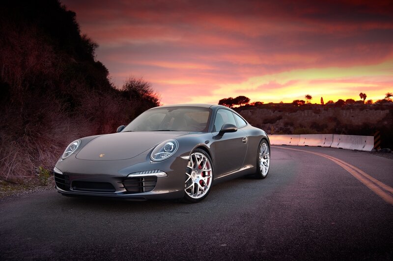 Porsche on a coastal road at sunset