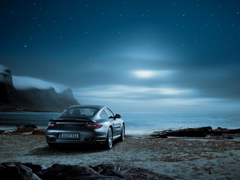 Porsche on a rocky beach at night