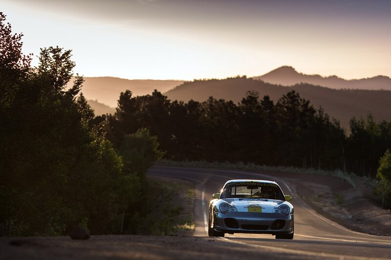 Porsche on a winding road at sunset