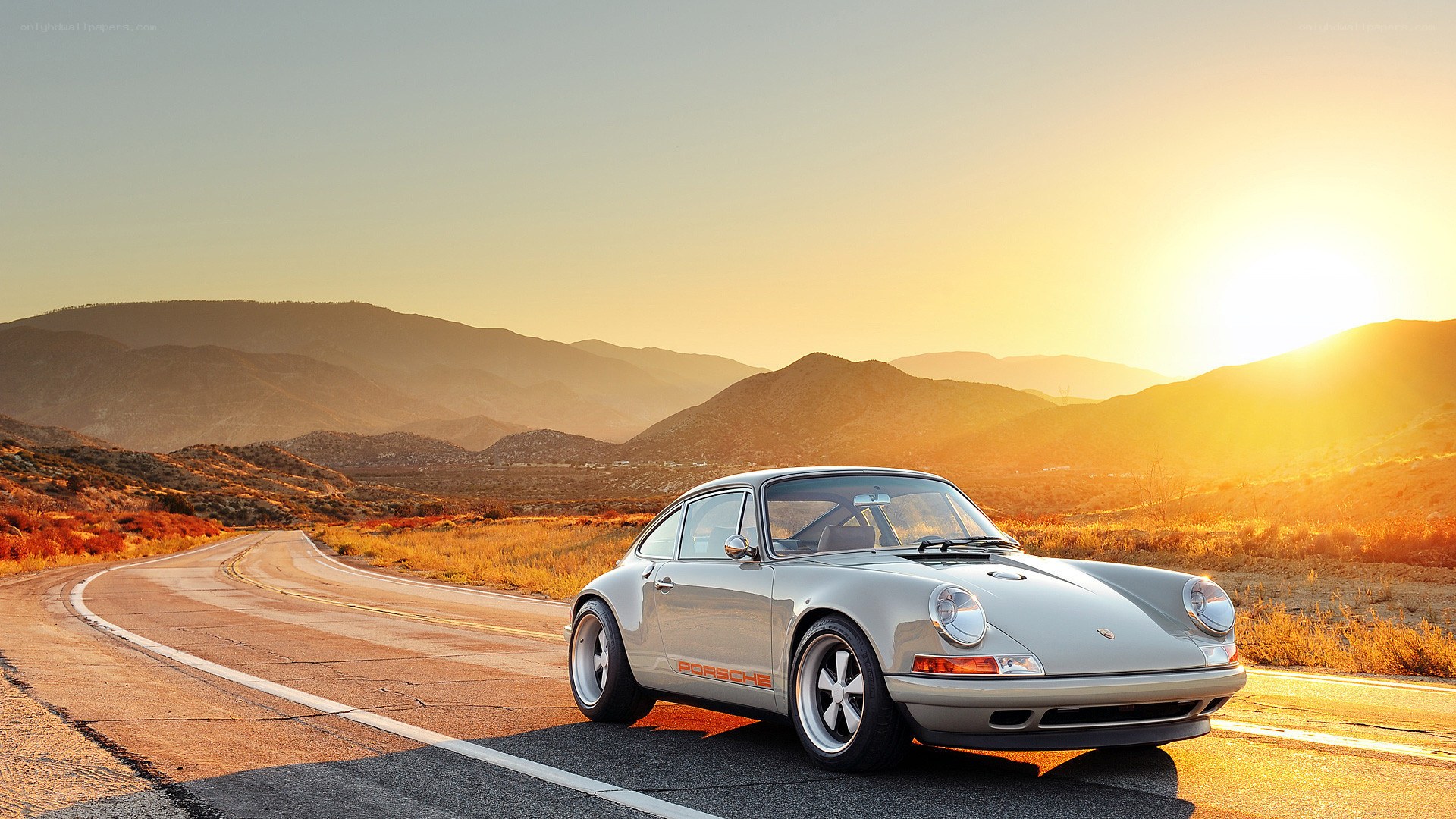 Porsche on a winding road at sunset