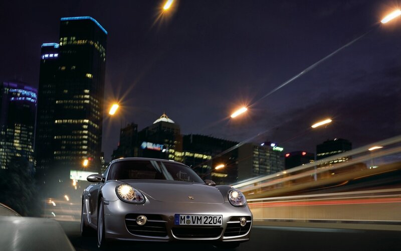 Porsche on city street at night