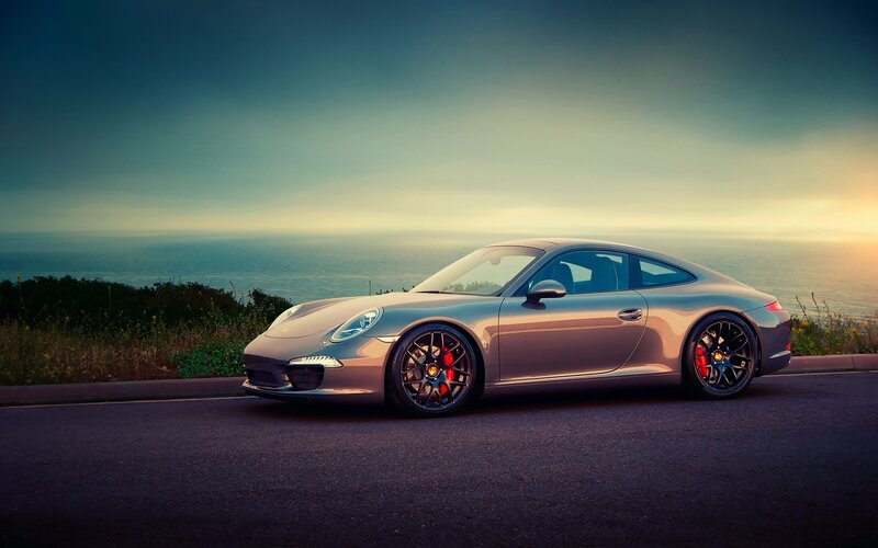 Porsche on coastal road at sunset