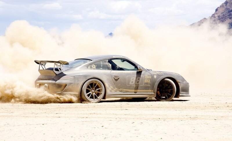 Porsche racing on dusty track