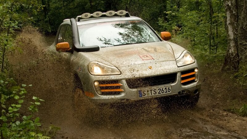 Porsche rally car on muddy forest trail