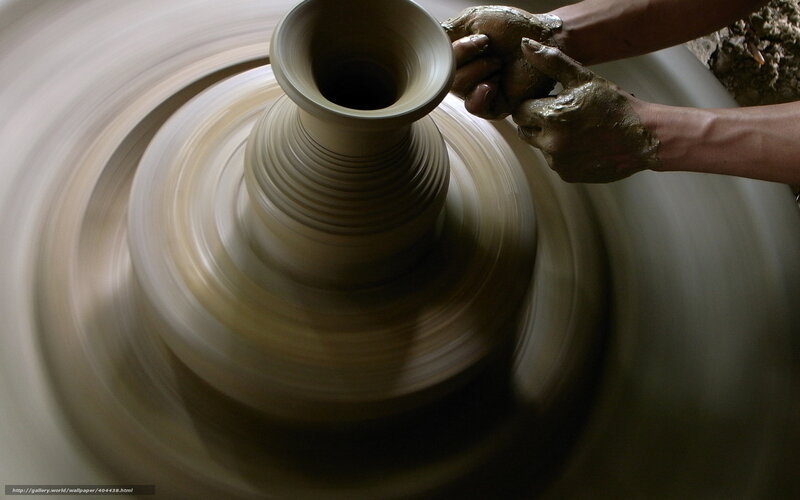 Potter shaping clay on wheel