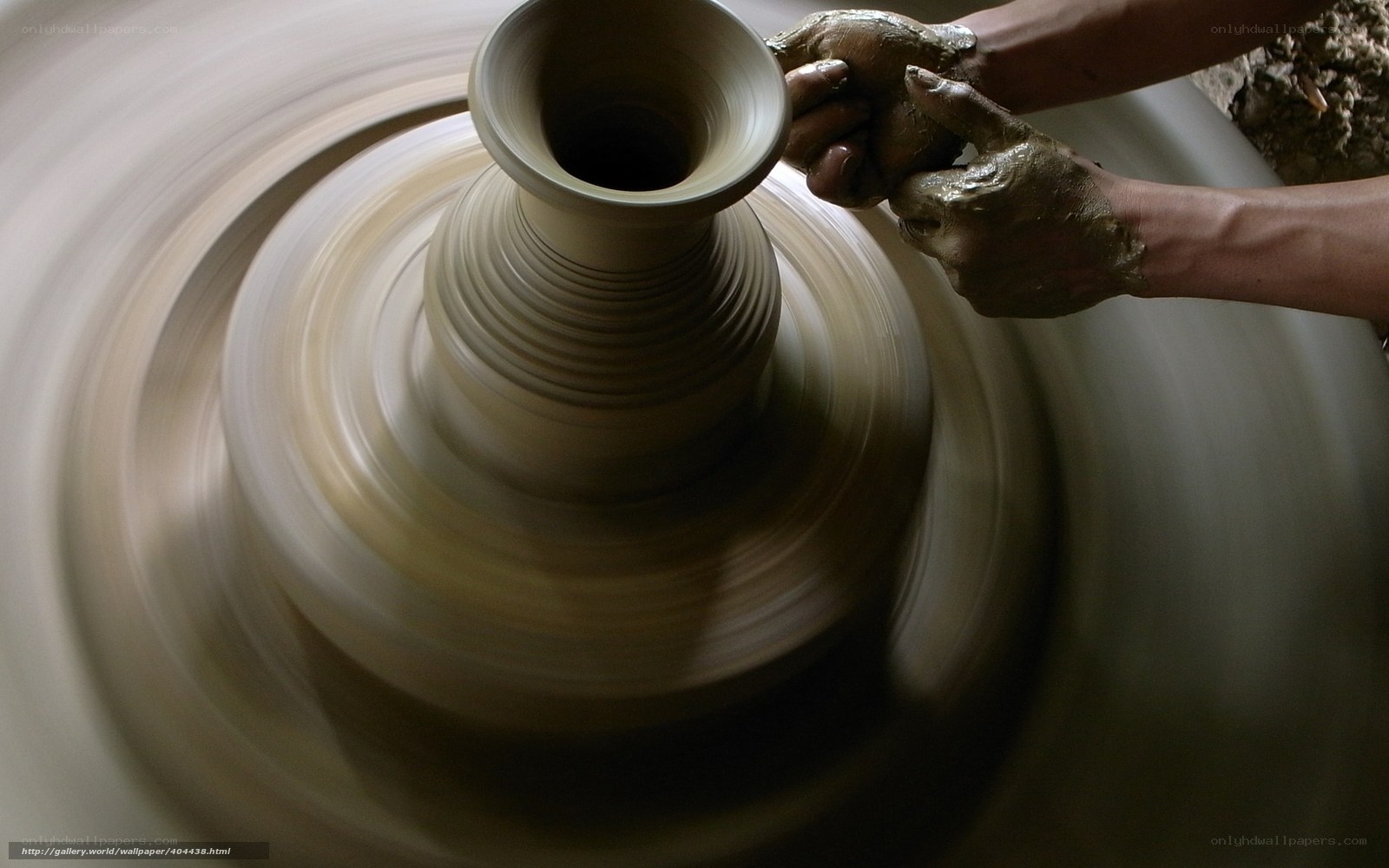 Potter shaping clay on wheel