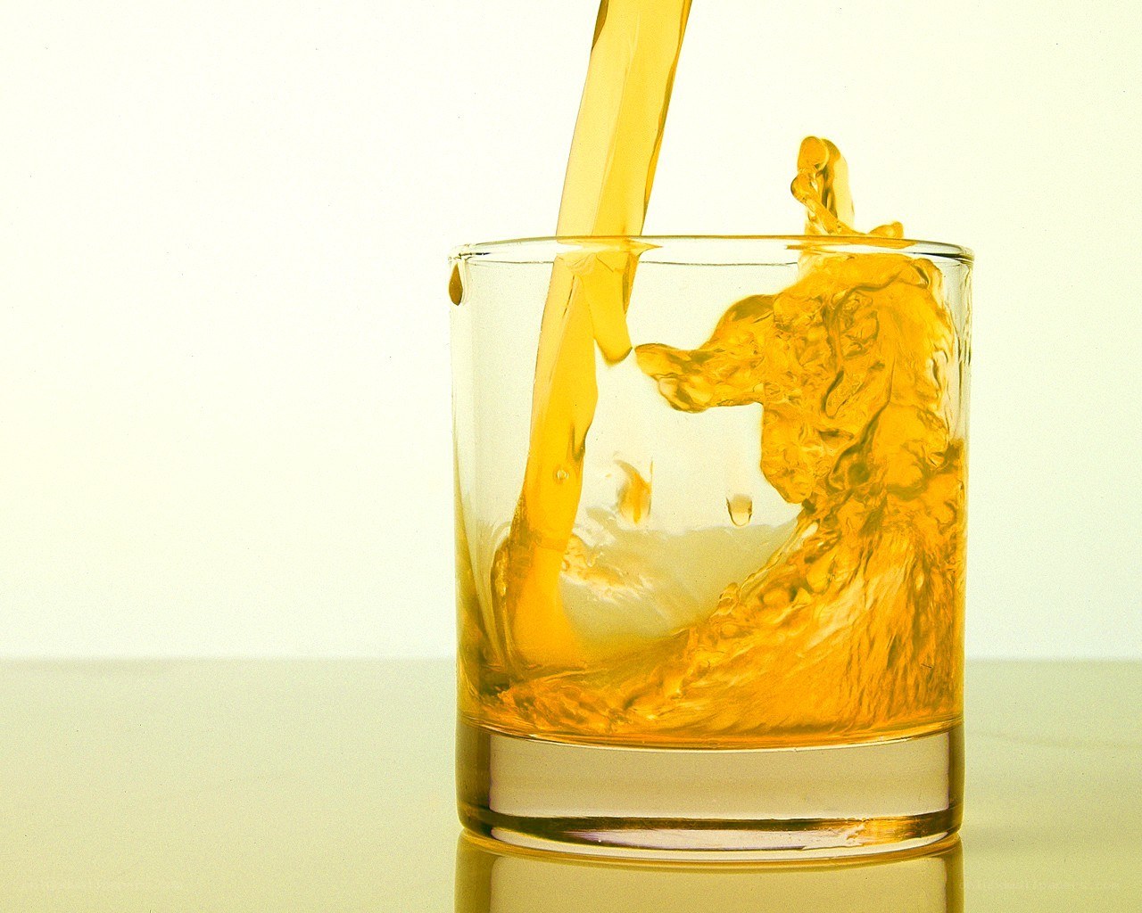 Pouring golden liquid into glass