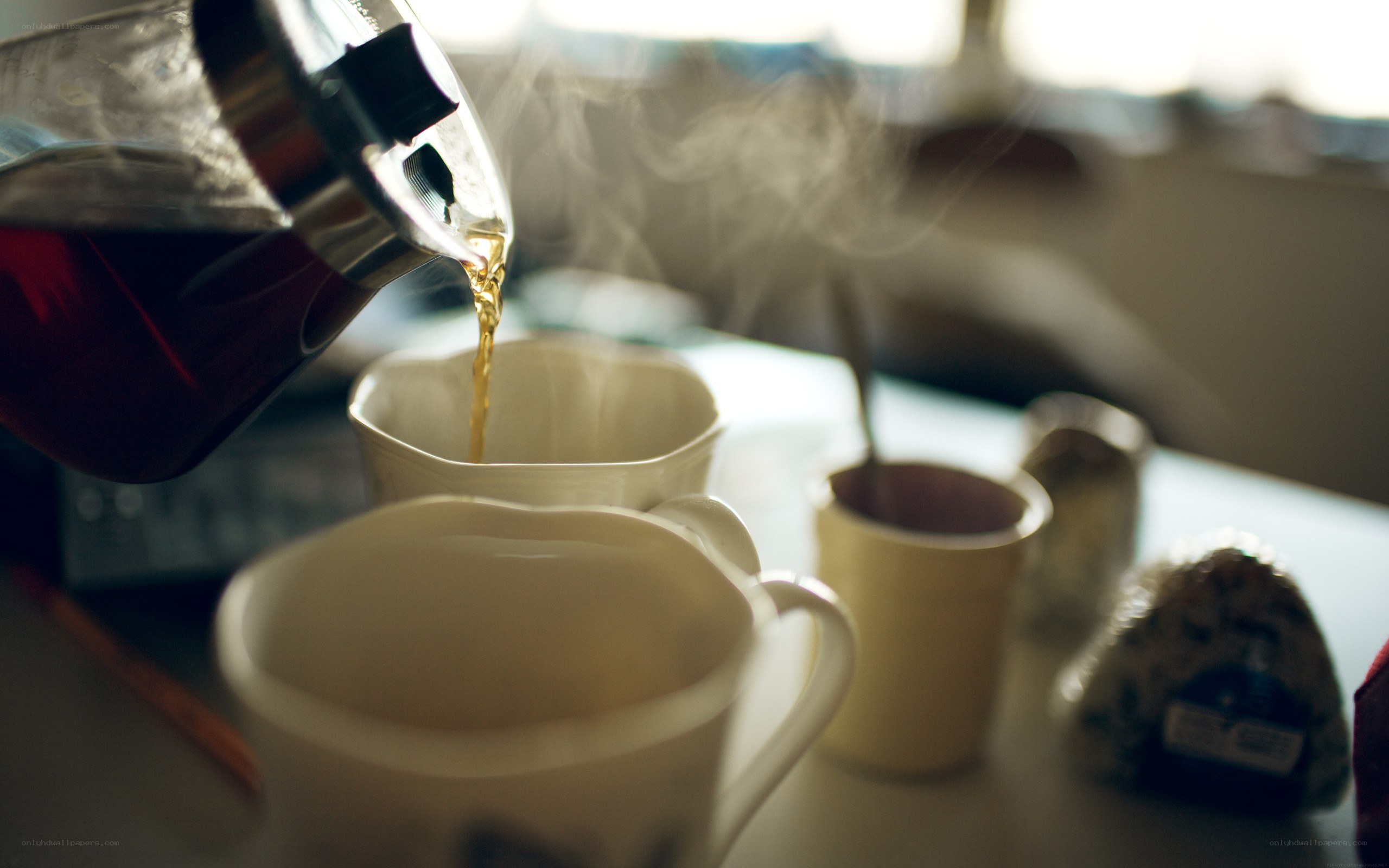 Pouring hot tea into mugs