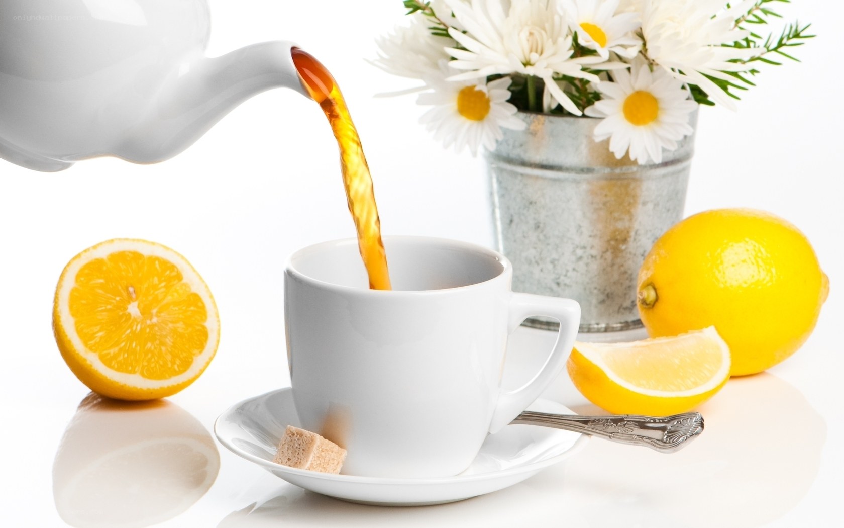 Pouring tea with lemon and flowers