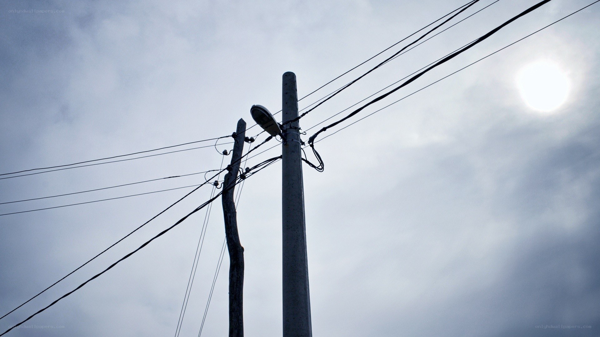 Power lines against cloudy sky