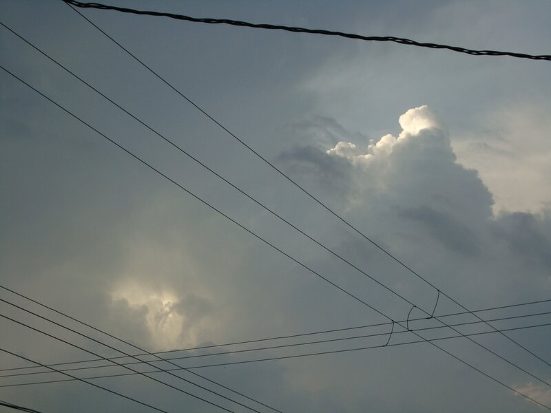 Power lines against cloudy sky