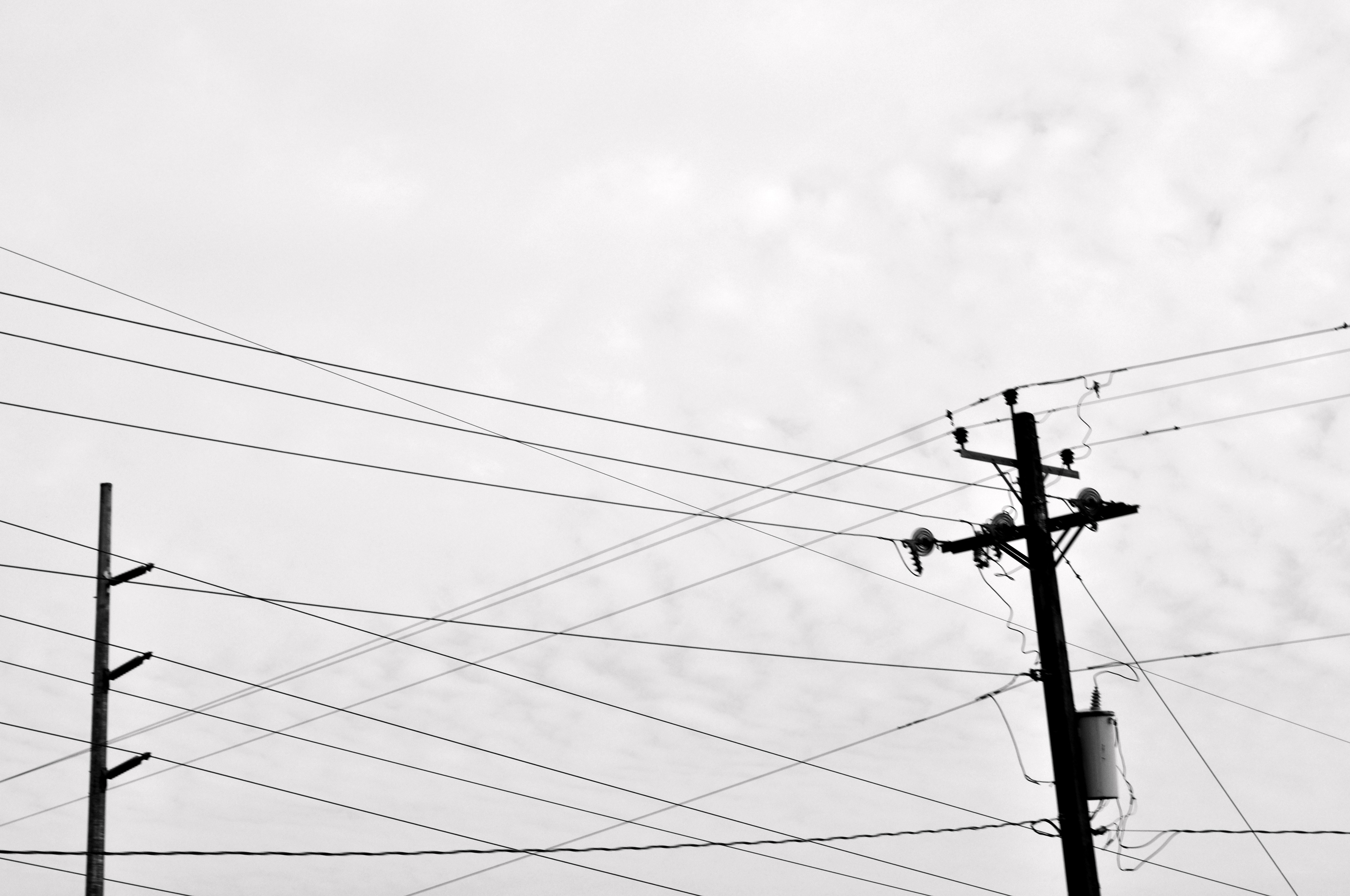Power lines against cloudy sky