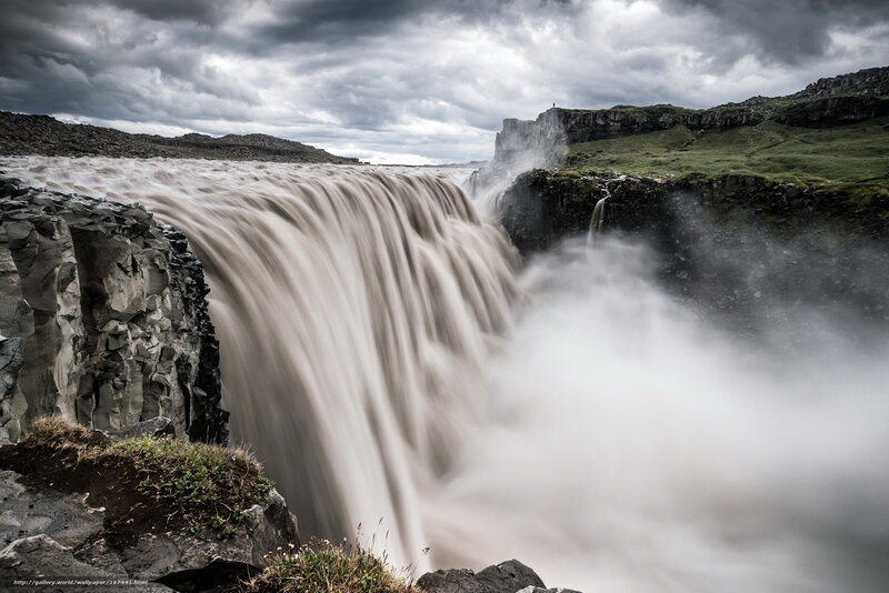 Powerful waterfall under stormy sky