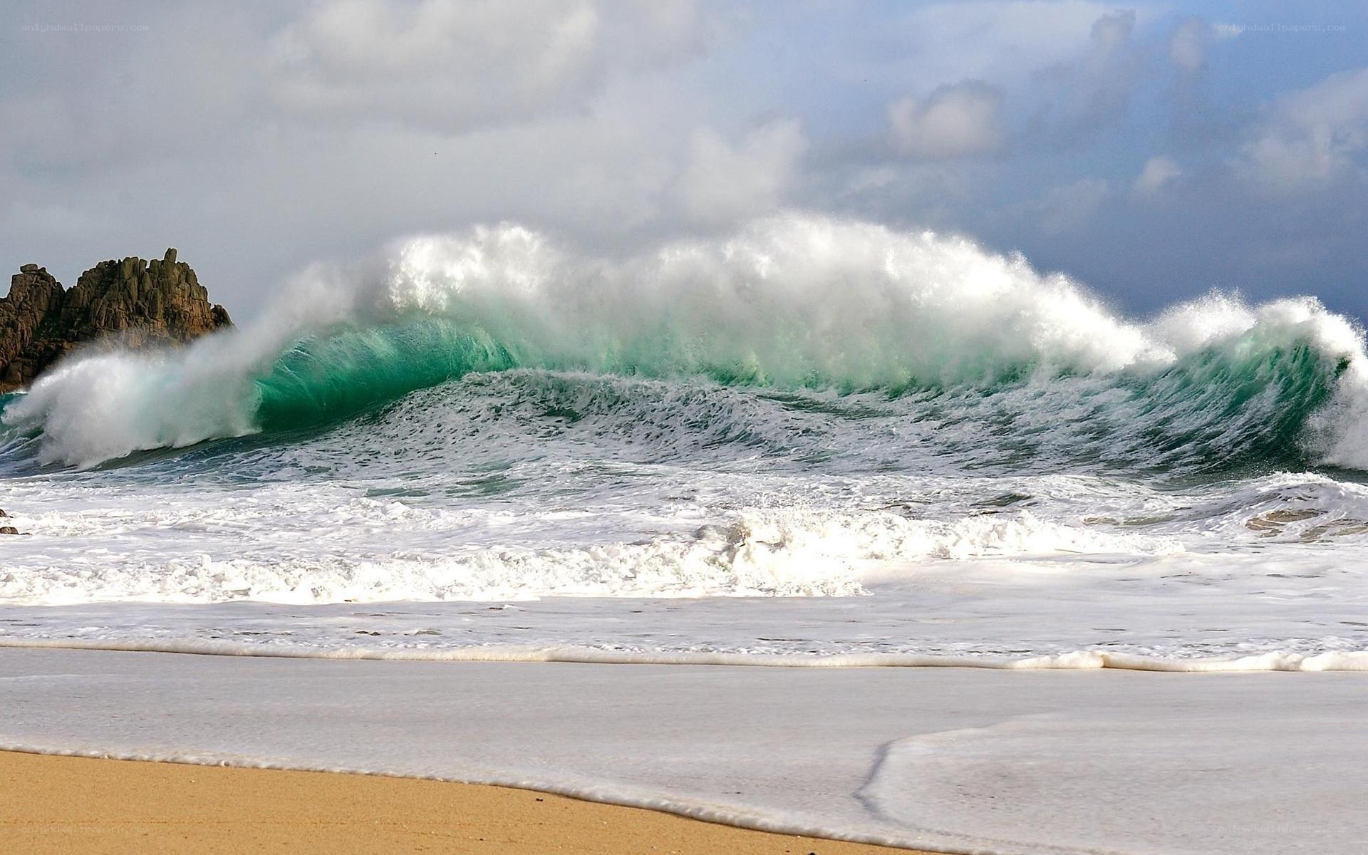 Powerful wave crashing on beach