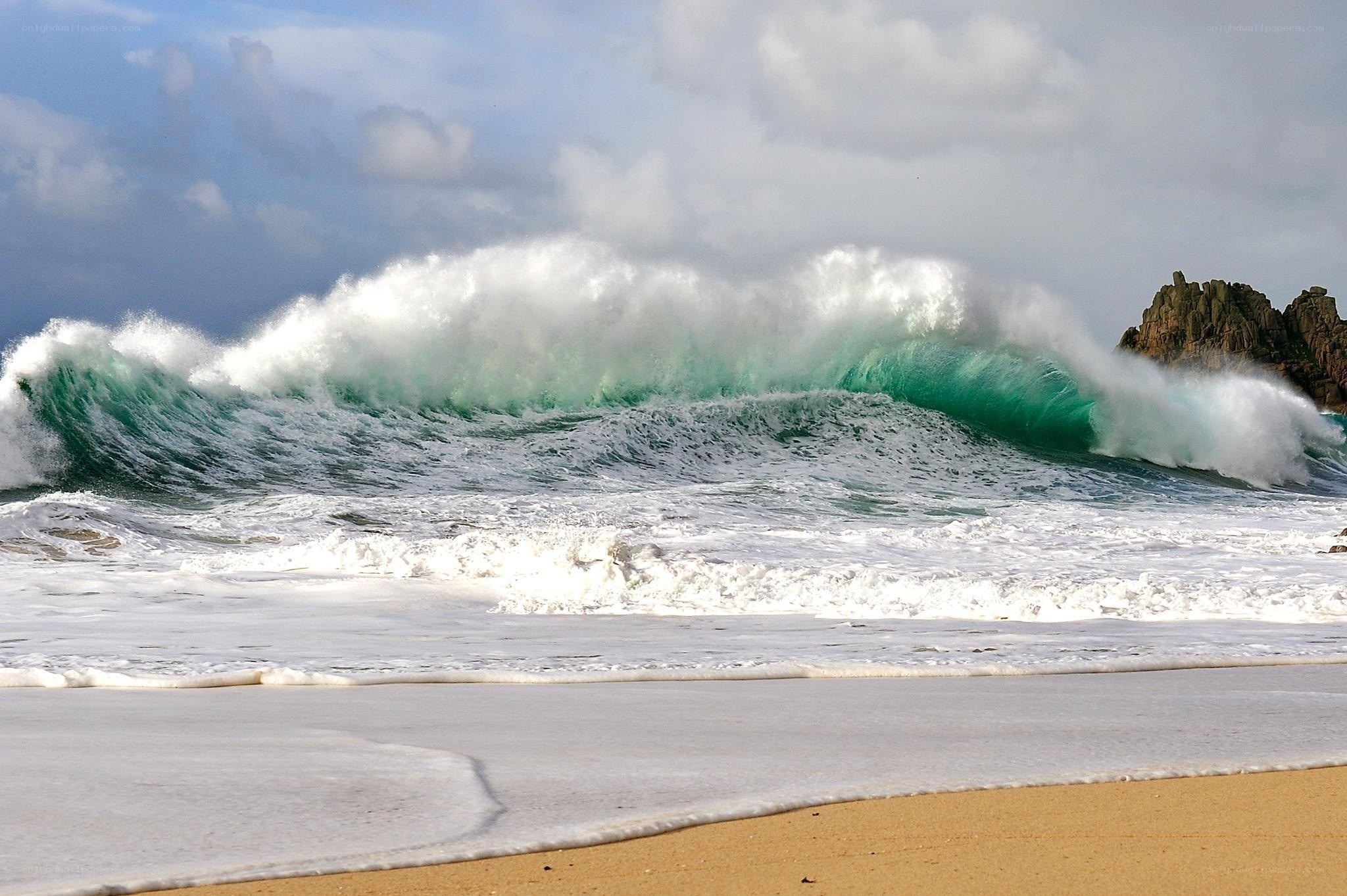 Powerful wave crashing on beach