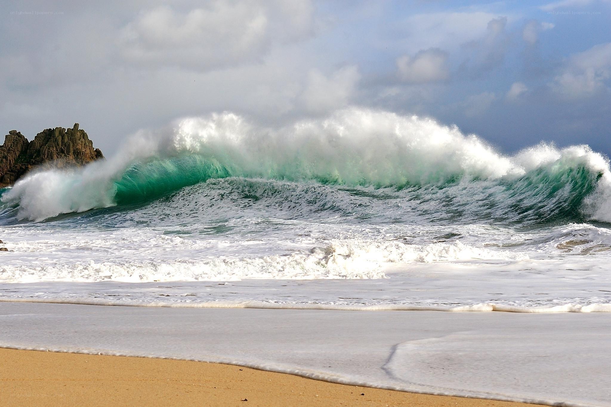 Powerful wave crashing on beach