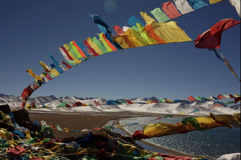 Prayer flags over a mountain lake