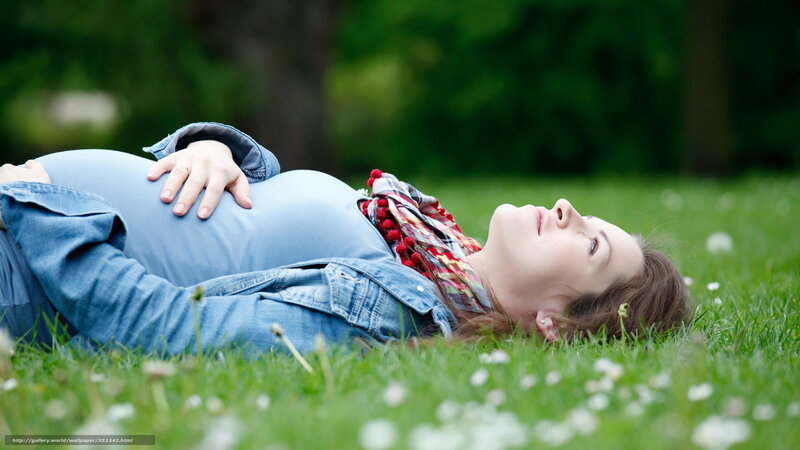 Pregnant woman resting on grass