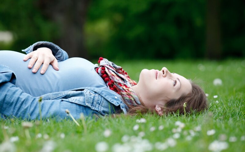 Pregnant woman resting on grass