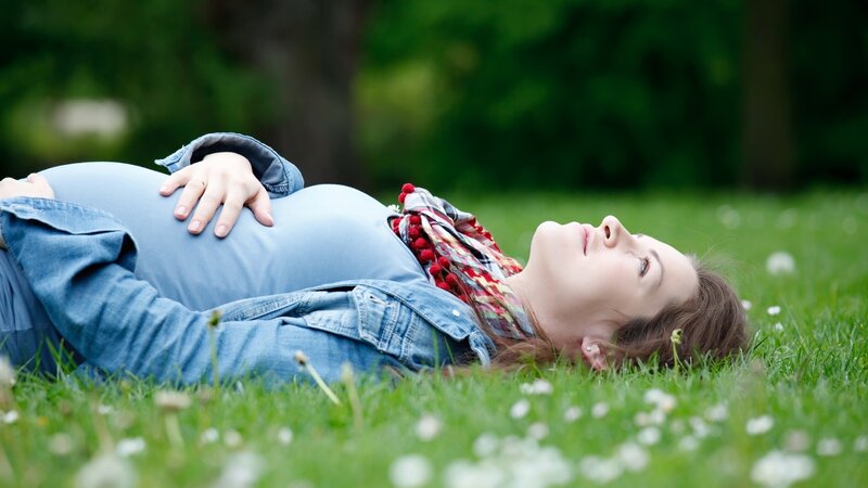 Pregnant woman resting on grass
