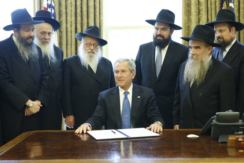 President signing document with rabbis