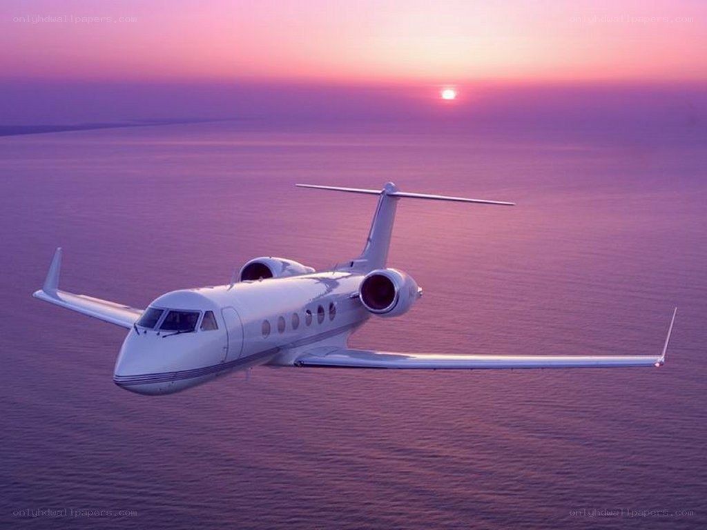 private jet at sunset over ocean