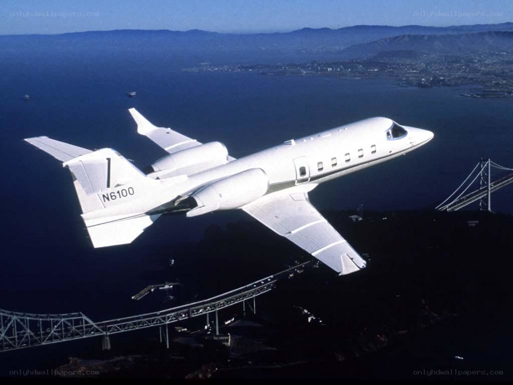 Private jet flying over bridge